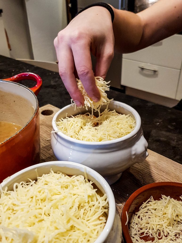 parsemer généreusement la soupe à l'oignon de fromage râpe