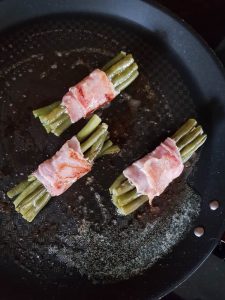 pan fry green beans and bacon bundles with butter