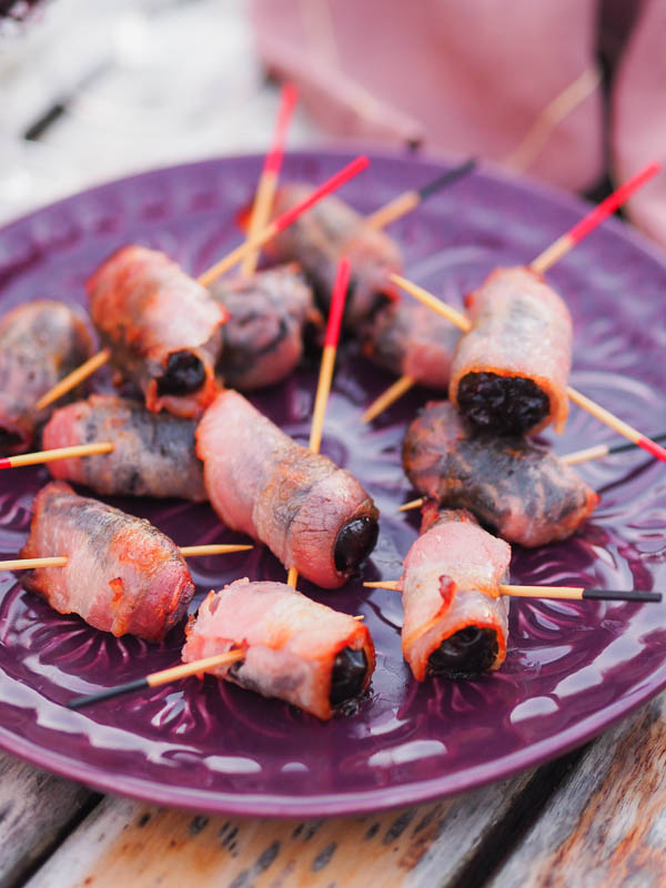 a plate of apero, bacon wrapped prunes