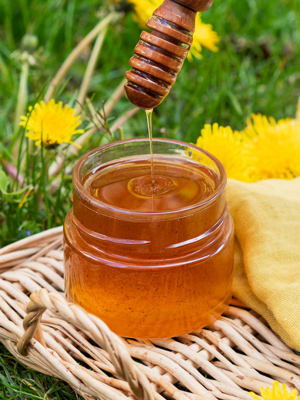 Un bocal de miel fait maison avec des fleurs de pissenlit